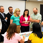 **

A diverse group of teachers actively participating in a hands-on simulation during a workshop. Some are role-playing, others are observing, all are visibly engaged and thoughtfully considering the challenges presented. Focus on capturing a sense of empathy and collaborative problem-solving.

**